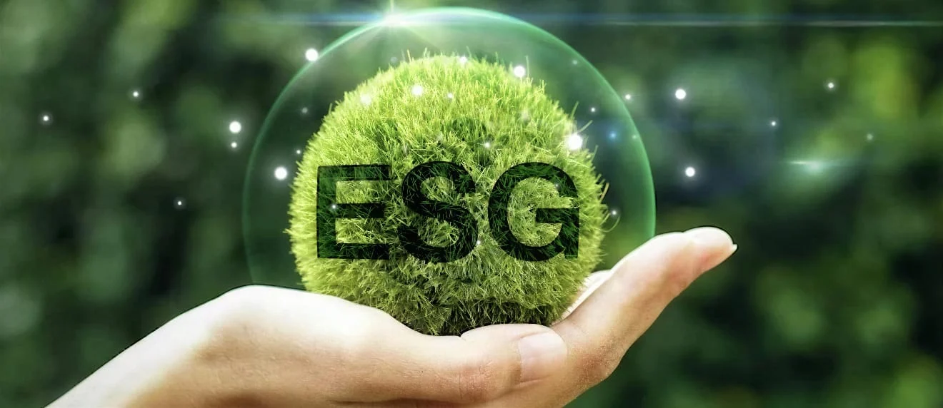 Mão sustenta uma esfera verde com a sigla ESG
