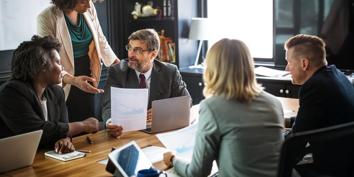 Lideran&ccedil;as analisando documentos e indicadores durante uma reuni&atilde;o