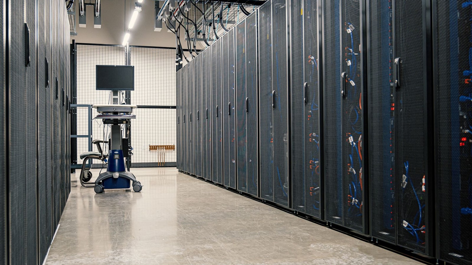 Corredor de data center com fileiras de racks de servidores