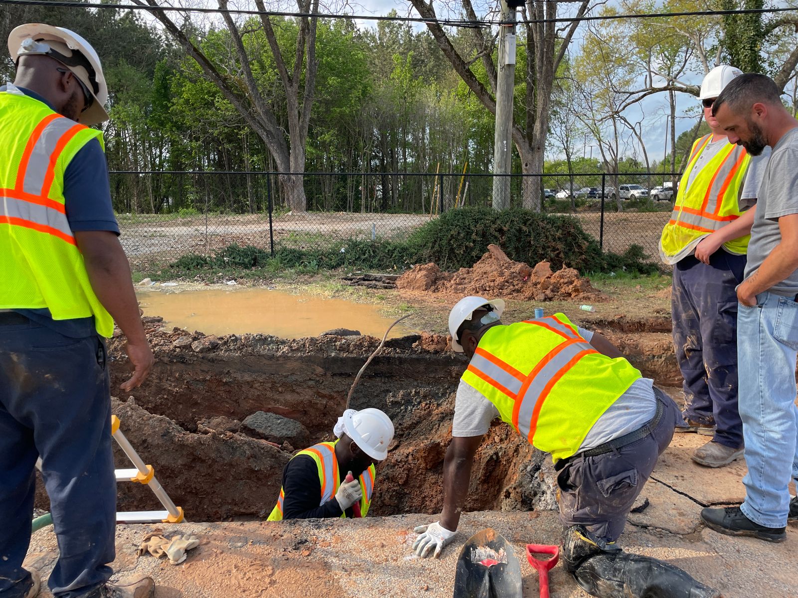 Equipe de obra inspecionando uma rede de infraestrutura subterrânea