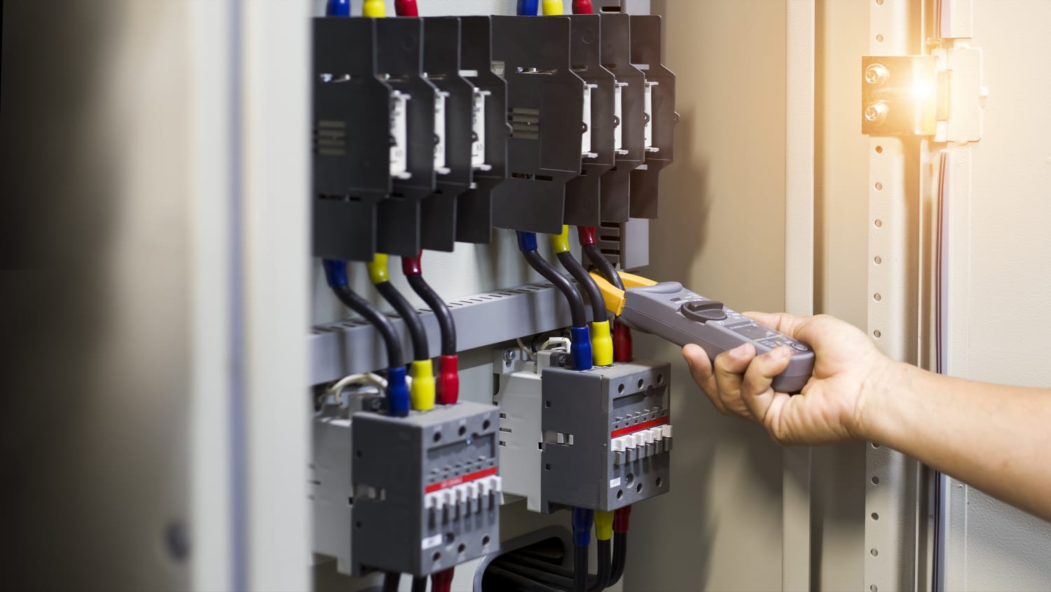Técnico inspecionando componentes de um quadro elétrico de distribuição